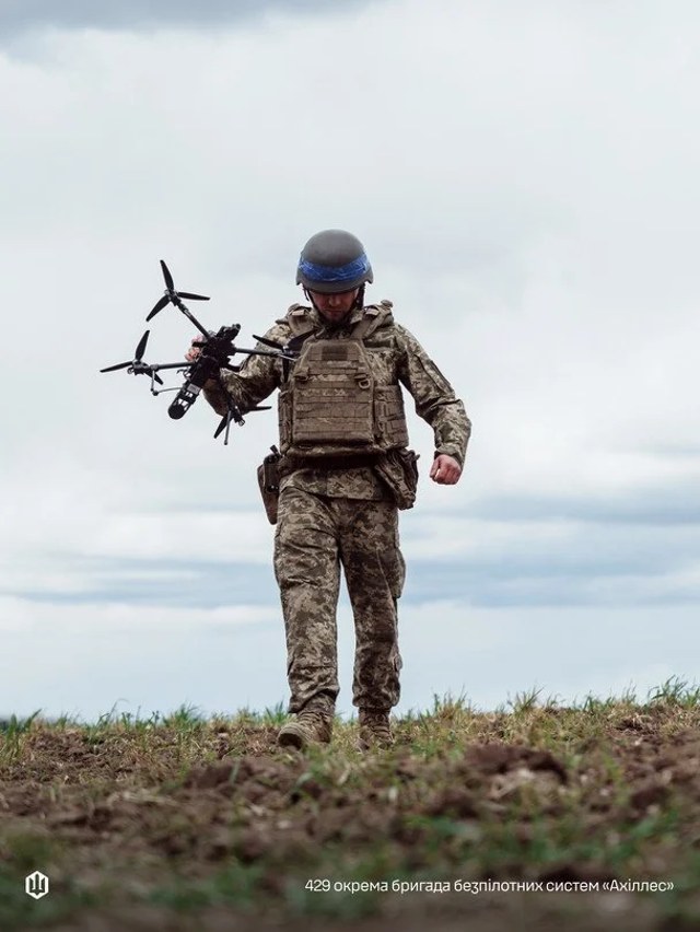 Український військовий із безпілотником на тлі роботи Сил безпілотних систем ЗСУ
