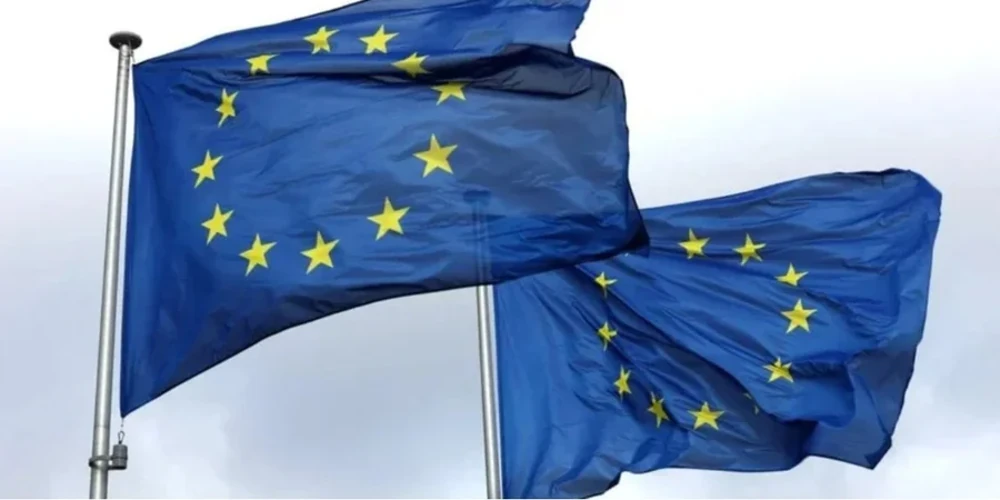 Друкований проєкт висновків саміту ЄС на тлі прапорів Європейського Союзу